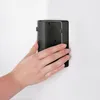 A hand is holding a black cosmetic bin against a white wall. Náhľad obrázku produktu