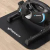 A close-up, angled view of a black MERACH S04B1 Mini-Heimtrainer placed on a black textured mat on a light brown wooden floor. Náhľad obrázku produktu