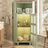 A green corner cabinet in a bathroom setting, with toiletries and decorative items displayed on its shelves. Produktbild-Vorschau