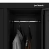 Interior of a black cabinet with two hangers holding clothes. Anteprima dell’immagine prodotto