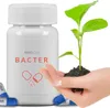 A bottle of Neo Cap Bacter is shown next to a hand holding a small plant growing from soil, with other capsules scattered around. Produktbild-Vorschau
