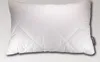 A white quilted pillow is shown against a light gray and white gradient background. Náhled obrázku produktu