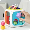 A hand is interacting with a colorful activity cube toy. Produktbild-Vorschau