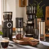 A collection of coffee grinders and a cup of coffee on a kitchen counter. Produktbild-Vorschau