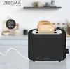 A black Zeegma toaster with two slices of bread in it, placed on a marble countertop in a kitchen setting. Produktbild-Vorschau