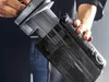 A person is holding and showing a part of a vacuum cleaner. Produktbild-Vorschau