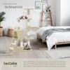 A cat tree is set up in a bedroom next to a bed. Produktbild-Vorschau