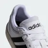 A close-up view of the top of a white Adidas sneaker with black stripes. Anteprima dell’immagine prodotto