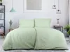 A bedroom scene with a bed made with green floral patterned bedding. Produktbild-Vorschau