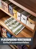 A striped bag with rope handles lies on a wooden shelf in a storage unit, with other storage boxes in the background. Produktbild-Vorschau