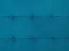 A close-up, full-frame shot of a tufted teal fabric surface, showing the texture and stitching of the material. Podgląd zdjęcia produktu