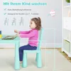 A young child is sitting at a green table and chair set, with measurement lines indicating dimensions. Produktbild-Vorschau