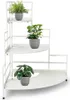 A white metal corner shelf with three tiers, holding three potted plants. Voir les images du produit
