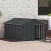 A dark gray dog house with a metal roof sits on a wooden deck next to a brick wall. A dog bowl is visible in the foreground. Anteprima dell’immagine prodotto