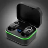 A pair of black wireless earbuds in a black charging case with a green LED light strip around the base. The charging case is open, revealing the earbuds nestled inside. A small blue digital display shows '100'. Podgląd zdjęcia produktu