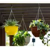 Three hanging planters with plants are displayed outdoors under a wooden pergola. Podgląd zdjęcia produktu