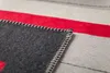 A close-up view of a blanket's edge, showing the stitching and fabric texture. Produktbild-Vorschau