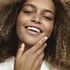 A close-up shot of a woman's hand wearing a Pandora ring, with her face partially visible. Produktbild-Vorschau
