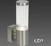 A modern outdoor wall light with a cylindrical frosted glass shade and a brushed metal base. Produktbild-Vorschau