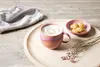 A coffee cup with latte art, cookies, and dried flowers on a wooden tray. Náhled obrázku produktu