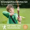 A young boy is shown aiming a bow and arrow outdoors. Anteprima dell’immagine prodotto