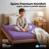 A young boy sitting cross-legged on a bed with a purple fitted sheet. Podgląd zdjęcia produktu