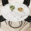 A round dining table with a marble-like top, set with a vase of flowers and a decorative tray, surrounded by black chairs. Produktbild-Vorschau