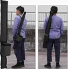 Two men are shown from different angles wearing a black laser telescoping pole bag over their shoulders. Produktbild-Vorschau