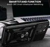 A black phone case with a ring stand is shown in a close-up shot, with a laptop and headphones blurred in the background. Produktbild-Vorschau