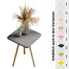 A square side table with wooden legs, decorated with a vase of dried flowers and a small green diffuser. Produktbild-Vorschau