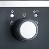A close-up view of the control panel of a coffee machine, featuring a large dial and several indicator lights and icons. Produktbild-Vorschau