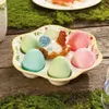 An Easter-themed egg plate with a decorative chicken figurine, set on a wooden surface with moss. Náhled obrázku produktu