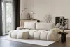 A modern living room with a cream bouclé sectional sofa. Produktbild-Vorschau