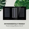 A black induction hob with an integrated ventilation system, presented on a light background with large green leaves. Náhľad obrázku produktu
