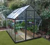 A greenhouse filled with plants in a garden setting. Produktbild-Vorschau