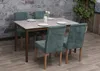 A dining table with four chairs set up in a room with a stone wall. Náhľad obrázku produktu