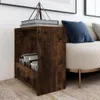 A dark wood side table with books on top and in the shelf, next to a sofa with a blue pillow. Produktbild-Vorschau