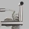 A close-up view of a brushed metal kitchen faucet with a coiled hose and spray nozzle. Produktbild-Vorschau