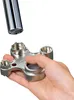 A hand holds a multi-tool designed for faucet aerators and cache regulators, with a faucet spout positioned above it. Náhľad obrázku produktu