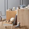 A collection of wooden bird figurines and decorative items arranged on wooden blocks and a wooden floor. Náhled obrázku produktu