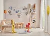 A child's nursery with a crib, toys, and wall decorations. Anteprima dell’immagine prodotto
