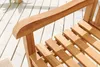 Close-up of a wooden garden bench armrest and seat slats on a wooden deck. Produktbild-Vorschau
