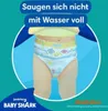 A close-up of a baby wearing diapers with Baby Shark characters, with promotional text above. Produktbild-Vorschau