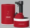 A red portable steam cleaner and its cylindrical packaging are displayed against a light gray background. The packaging has a line drawing of the steam cleaner and the brand name 'IGGI' printed on it. Anteprima dell’immagine prodotto