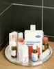 A collection of medical supplies and bottles arranged on a silver rotating tray, with a dark tiled background. Anteprima dell’immagine prodotto