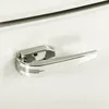 A close-up shot of a chrome refrigerator handle on a white refrigerator. Produktbild-Vorschau