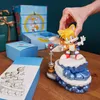 A hand is placing a Tails figurine on a display stand, surrounded by gift boxes and packaging. Podgląd zdjęcia produktu