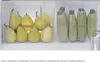 A close-up view of two transparent drawers in a refrigerator, filled with pears and zucchini. Produktbild-Vorschau