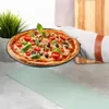 A pizza is being held over a light green mat on a kitchen counter. Náhľad obrázku produktu