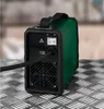 The back of a green and black inverter welding machine is shown on a textured metal surface. Produktbild-Vorschau